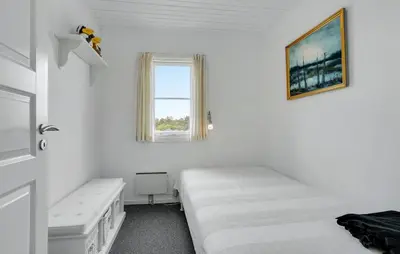 a white room with two beds and a window at Agger Havn Feriecenter in Vestervig