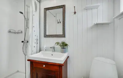 a bathroom with a sink and a mirror and a toilet at Agger Havn Feriecenter in Vestervig
