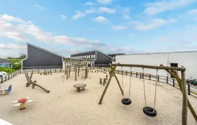 an outdoor playground with swings and swings at Agger Havn Feriecenter in Vestervig