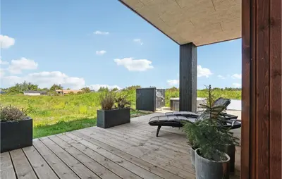 a wooden deck with a bench and potted plants at 3 Bedroom Amazing Home In Thisted in Thisted