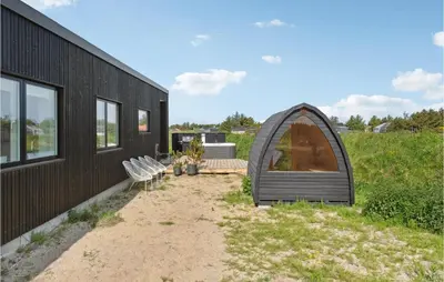 a black tiny house with a patio and a backyard at 3 Bedroom Amazing Home In Thisted in Thisted