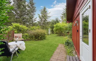 a patio with a table and a chair and a yard at 3 Bedroom Cozy Home In Spøttrup in Spottrup