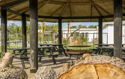 a picnic shelter with picnic tables and a swing at Lovely Home In Vestervig With Kitchen in Vestervig
