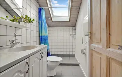 a bathroom with a toilet and a sink and a window at Lovely Home In Roslev With Wifi in Roslev