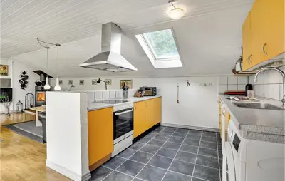 a kitchen with yellow and white cabinets and a window at Lovely Home In Roslev With Wifi in Roslev