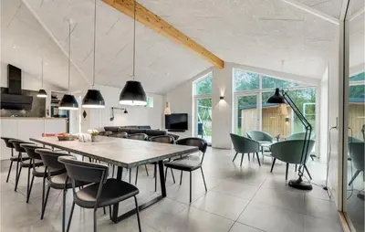 a kitchen and dining room with a table and chairs at Amazing Home In Blokhus With Sauna in Blokhus