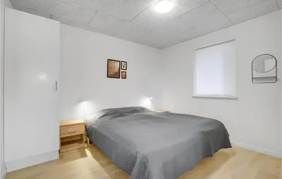 a bedroom with a bed and a nightstand and a window at Lovely Home In Thisted in Thisted