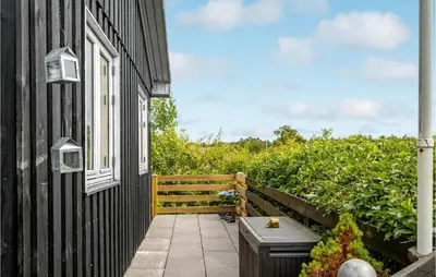 a black house with a window and a patio at Cozy Home In Roslev With Wifi in Roslev