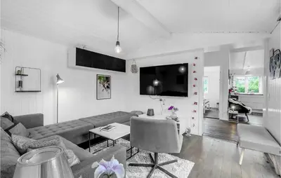 a living room with a couch and a flat screen tv at Cozy Home In Roslev With Wifi in Roslev