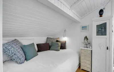a bedroom with a white bed with pillows on it at Lovely Home In Roslev With Kitchen in Roslev