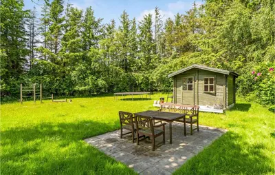 a table and chairs in a yard with a smallshed at Lovely Home In Spøttrup in Spottrup
