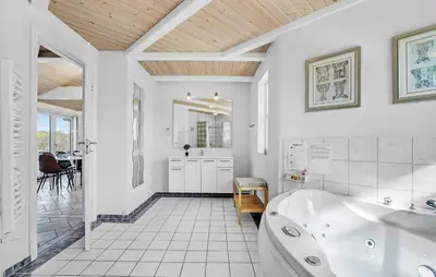 a white bathroom with a tub and a table at Stunning Home In Vestervig With Sauna in Vestervig