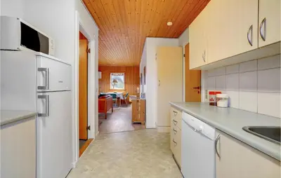 a kitchen with white appliances and a dining room at Gorgeous Home In Harboøre With Wifi in Harboør