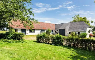 a white house with a red roof and a yard at Cozy Home In Nykøbing M With Kitchen in Tæbring