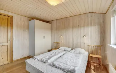 a bedroom with a bed in a room with wooden walls at Awesome Home In Lemvig With Wifi in Lemvig