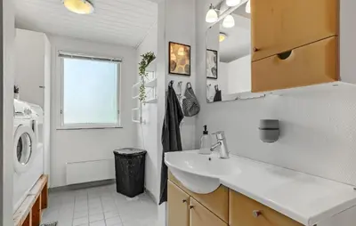 a bathroom with a sink and a washing machine at Nice Home In Roslev With Kitchen in Roslev