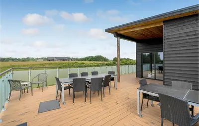 a deck with a table and chairs on it at Lovely Home In Spøttrup With Wifi in Spottrup