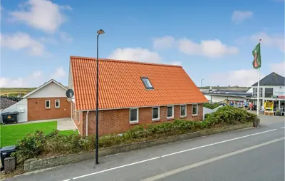 an orange roofed building on the side of a street at Amazing Home In Vestervig With Sauna in Vestervig