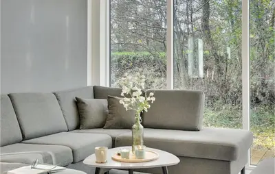 a living room with a couch and a table with flowers at Nice Home In Hurup Thy With Wifi in Sindrup