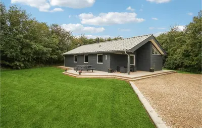a small gray house with a picnic table in a yard at Nice Home In Hurup Thy With Wifi in Sindrup