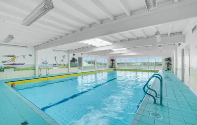 a large indoor swimming pool with blue water at Awesome Apartment In Vestervig in Vestervig