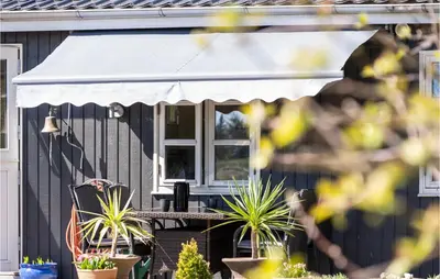 a white awning on a house with potted plants at 4 Bedroom Stunning Home In Thyholm in Thyholm