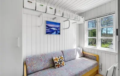 a living room with a couch and two windows at 4 Bedroom Stunning Home In Thyholm in Thyholm