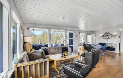 a living room with a couch and a table at 4 Bedroom Stunning Home In Thyholm in Thyholm
