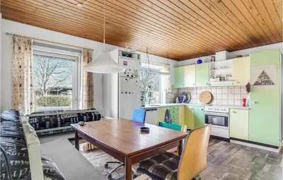 a kitchen with a wooden ceiling and a table and chairs at Beautiful Home In Nykøbing M With Wifi in Sønder Dråby