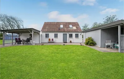 a white house with a green lawn in front of it at 1 Bedroom Beautiful Home In Roslev in Roslev