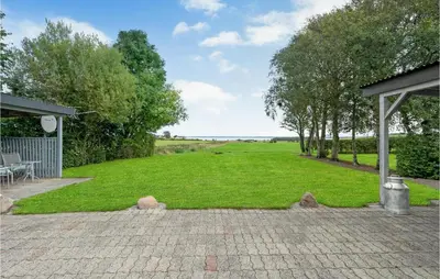 a large yard with a patio and a field of grass at 1 Bedroom Beautiful Home In Roslev in Roslev