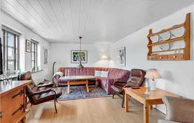 a living room with a couch and a table at 1 Bedroom Beautiful Home In Roslev in Roslev