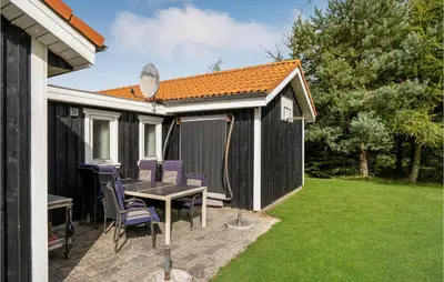 a backyard patio with a table and chairs at Stunning Home In Løgstør With Wifi in Løgstør