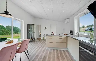 a kitchen with white counters and a table with chairs at Amazing Home In Spøttrup With Wifi in Spottrup