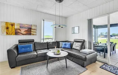 a living room with a leather couch and a table at Gorgeous Home In Løgstrup With Kitchen in Løgstrup