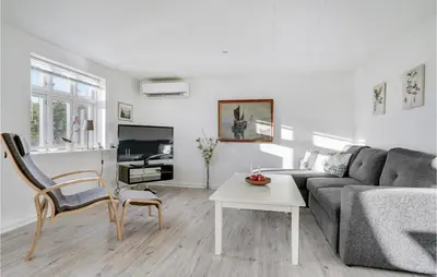 a living room with a couch and a table at Nice Home In Bedsted Thy in Bedsted Thy