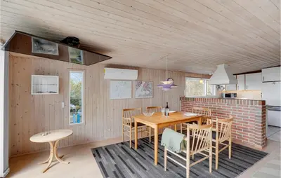 a kitchen and dining room with a wooden table and chairs at Awesome Home In Roslev With Kitchen in Roslev