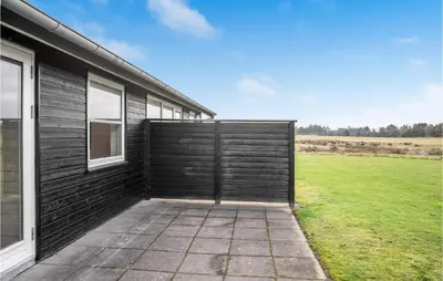 a wooden garage door on the side of a house at Beautiful Home In Pandrup With Wifi in Pandrup