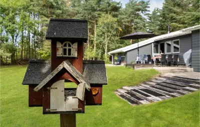 a bird house on a pole in a yard at Amazing Home In Farsø With Wifi in Farsø