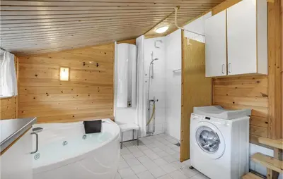 a bathroom with a tub and a washing machine at Amazing Home In Farsø With Wifi in Farsø