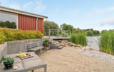 a patio with a bench and a building and water at 2 Bedroom Awesome Home In Vemb in Vemb