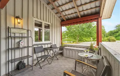 a patio with chairs and a table and a window at 2 Bedroom Awesome Home In Vemb in Vemb