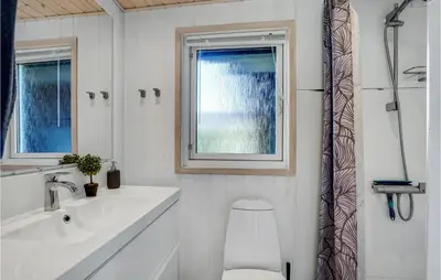 a bathroom with a sink and a toilet and a window at Lovely Home In Løgstør With Kitchen in Løgstør