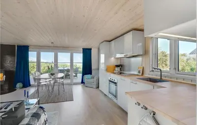 a kitchen and living room with a table and chairs at Lovely Home In Løgstør With Kitchen in Løgstør