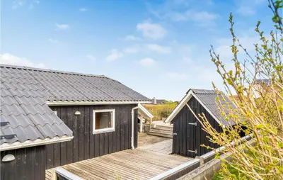 a black house with a wooden deck at Stunning Home In Lemvig With Wifi in Lemvig