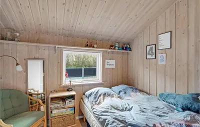 a bedroom with a bed in a room with wooden walls at Stunning Home In Lemvig With Wifi in Lemvig
