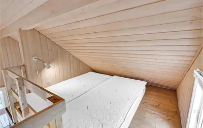 a small room with a bed in a wooden room at Lovely Home In Hanstholm With Wifi in Hanstholm