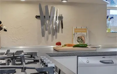 a kitchen with knives hanging on a wall at Nice Home In Thyborøn With Wifi in Thyborøn