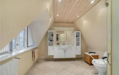 an attic bathroom with a sink and a toilet at Nice Home In Thyborøn With Wifi in Thyborøn