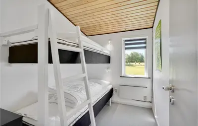 a bedroom with two bunk beds and a window at 3 Bedroom Lovely Home In Spøttrup in Spottrup